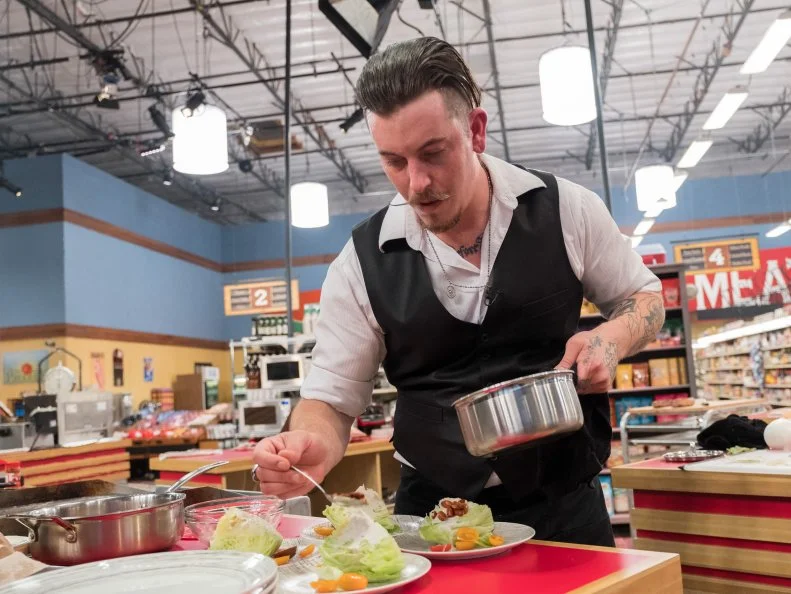 Contestant Mark Mishalanie puts the finishing touches on his dish, as seen on Food Network's Guy's Grocery Games, Season 12.