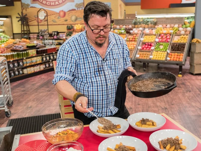 Contestant Tom Ramsey puts the finishing touches on his dish, as seen on Food Network's Guy's Grocery Games, Season 12.