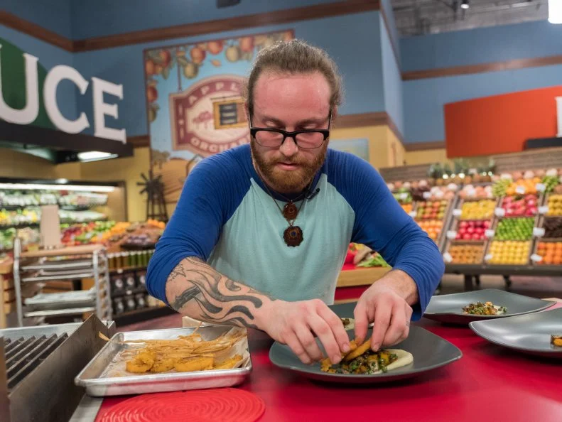 Contestant Jordan Cersnie plates his dish, as seen on Food Network's Guy's Grocery Games, Season 12.