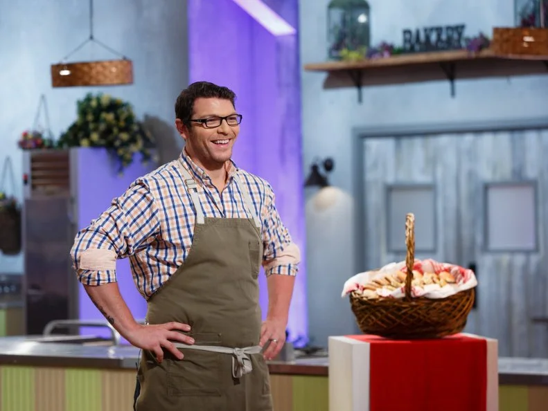 Contestant Adam Young reacts as he describes his trio of desserts including balsamic glazed vegetable quiche, s'mores macaroon, and strawberry shortcake profiterole, during the judging of the sweet-and-savory-themed pre-heat challenge, as seen on Food Network's Spring Baking Championship, Season 3.