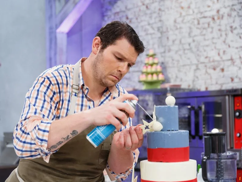 Contestant Adam Young assembles a flags-themed All-American chocolate cake with strawberry ice cream, during the main-heat challenge, as seen on Food Network's Spring Baking Championship, Season 3.