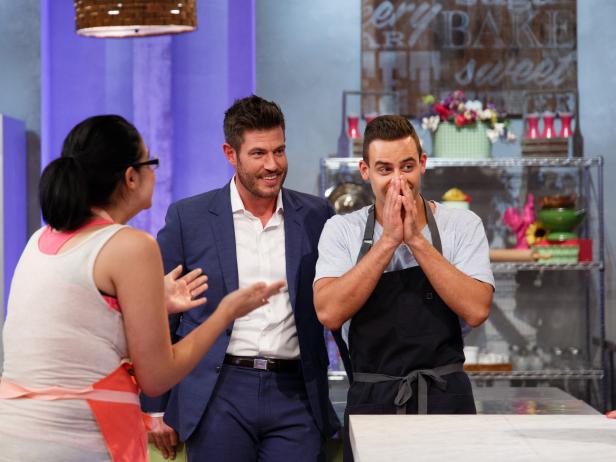 Contestant Jordan Pilarski (r.) stands next to host Jesse Palmer after being declared winner of the main-heat challenge, as seen on Food Network's Spring Baking Championship, Season 3.