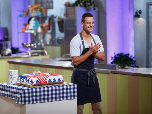 Contestant Jordan Pilarski describes his flags-themed Banana pound cake with swiss buttercream filling and caramelized bananas, during the judging of the main-heat challenge, as seen on Food Network's Spring Baking Championship, Season 3.