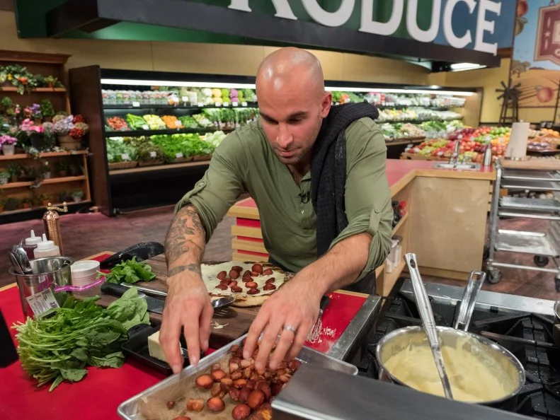 Contestant AJ Fusco prepares his pizza, as seen on Food Network's Guy's Grocery Games, Season 12.