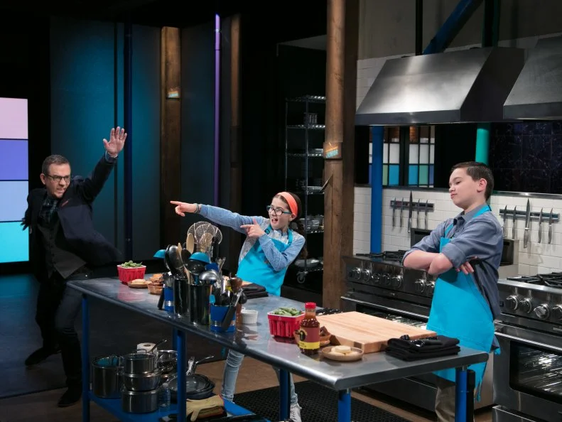 Host Ted Allen (L) and Junior contestants Sophie Remisio, and Ryan Gonzalez strike a pose during the appetizer round, as seen on Food Network's Chopped Junior, Season 6.