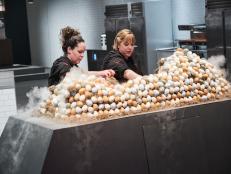 Chefs Sarah Grueneberg and Stephanie Izard grabbing eggs during the Secret Ingredient Showdown, as seen on Iron Chef Gauntlet, Season 1.