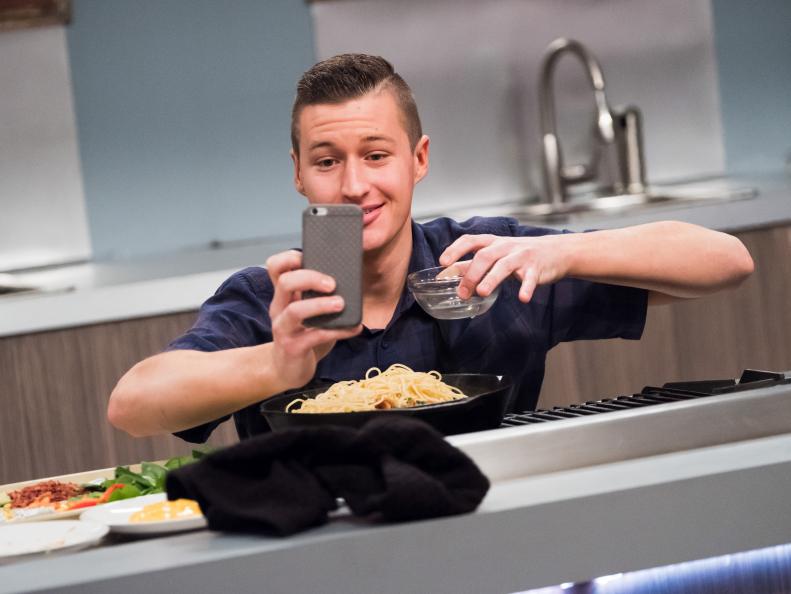 Contestant Matthew Grunwald recording his Instagram story on salad bar hacks  for the Mentor Challenge Passing the Bar, as seen on Food Network's Comeback Kitchen, Season 2.
