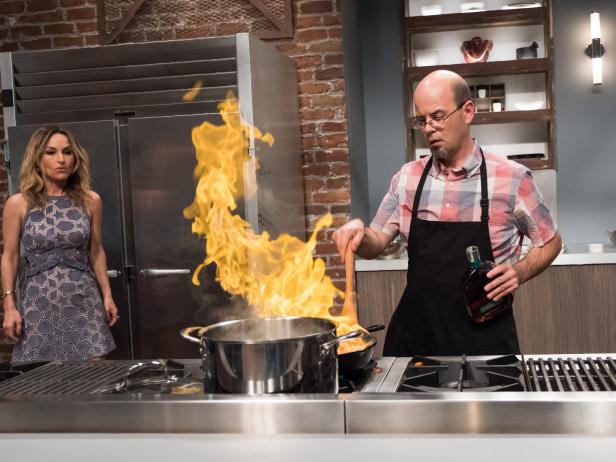 Mentor Giada De Laurentiis checks in on Contestant Jason Smith flaming up his dish, Uptown Sweet Taters, for the Mentor Challenge The Humble Potato, as seen on Food Network Star, Season 13.