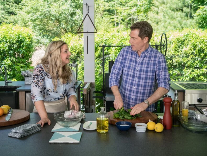 Bobby Flay and Damaris Phillips on the patio at Bobby's East Hampton, NY home, as seen on The Bobby and Damaris Show, Season 1.