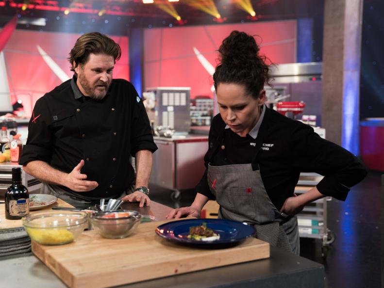 Contestant David LeFevre and Iron Chef Stephanie Izard discuss David's dish: Grilled Goat with Moroccan BBQ Sauce and Couscous, as seen on Iron Chef Gauntlet, Season 2.