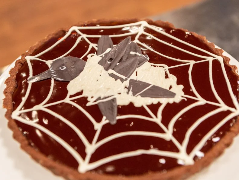 Contestant Steven Vaargas' completed dish from the pre-heat challenge, Hazelnut cherry raven tart, as seen on Food Network's Halloween Baking Championship Season 4.