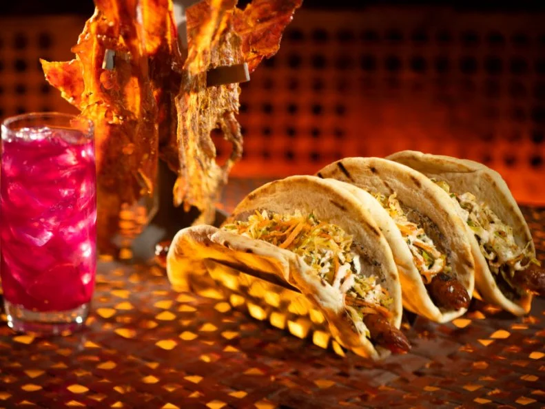 Guests will discover innovative and creative eats from around the galaxy at Star Wars: Galaxy's Edge at Disneyland Park in Anaheim, California and at Disney's Hollywood Studios in Lake Buena Vista, Florida. Pictured here, left to right, are the Meiloorun Juice, the Nuna Turkey Jerky and the Ronto Wrap filled with roasted pork, grilled sausage, peppercorn sauce and tangy slaw wrapped in pita found at Ronto Roasters, located in the Black Spire Outpost market. (Kent Phillips/Disney Parks)