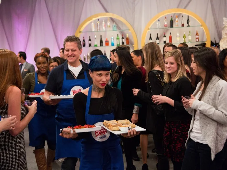 The Blue Team arrives at the surprise party with their dishes, for the Surprise Party Challenge. The teams supplied the party's hors d'oeuvre, based on Blue Team Leader Chef Bobby Flay's and Red Team Leader Chef Anne Burrell's own recipes for spring rolls and stuffed vegetables, as seen on Food Network's Worst Cooks in America, Season 5.