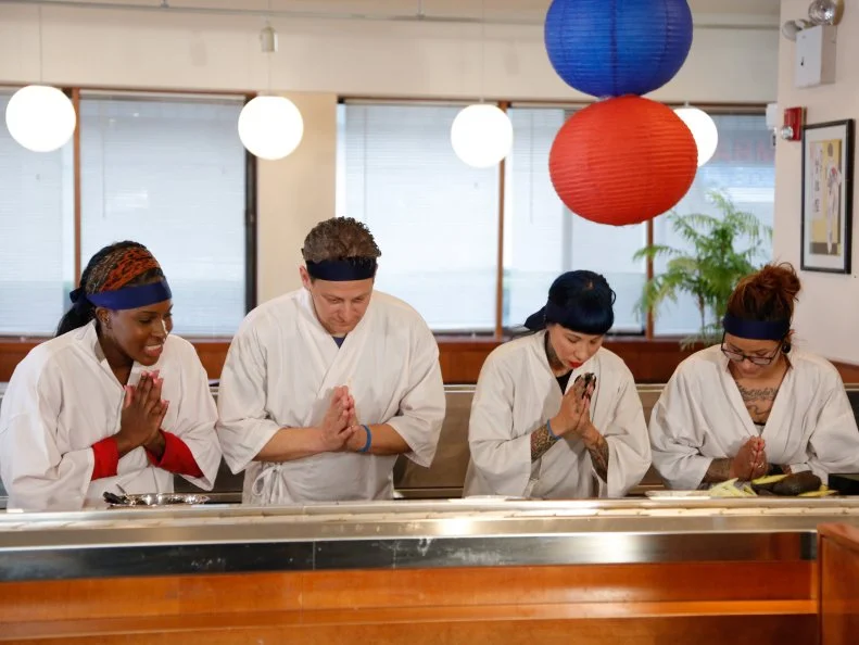 Blue Team members bow at the end of lunch service during the Sushi Skill Drill Challenge. The Red and Blue team recruits must prepare two sushi dishes for a hungry lunchtime crowd and are tested on both their time & quantity: A California Roll with snow crab, nori, rice on the outside, garnished with sesame seeds and a Salmon Roll with sliced salmon, scallion, sushi rice, spicy mayo (with nori on the outside.)  The diners will determine which team will the challenge, as seen on Food Network's Worst Cooks in America, Season 5.