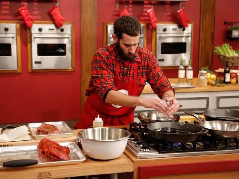 Mike Glazer of the Red Team gets ready to prepare his steak for the Surf and Turf Challenge. Each team must replicate a steak and lobster dinner from scratch, demonstrated to them by their team leader; Grilled Ribeye with Fra Diavolo Lobster Relish by Chef Bobby Flay for the Blue Team, and Dry Rubbed Rib Eye with Chili Lobster by Chef Anne Burrell for her Red Team, as seen on Food Network's Worst Cooks in America, Season 5.