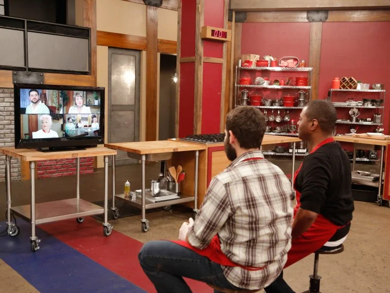 Red Team recruits Jamie Thomas and Mike Glazer watch their loved ones on a TV monitor and react to their comments as they taste the recruits' dishes and try to determine who made which dish, and which they like better, during the Feed the Family Challenge, as seen on Food Network's Worst Cooks in America, Season 5.