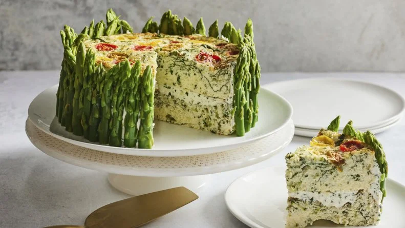 Description: Food Network Kitchen's 4-Cheese Garden Vegetable Frittata. Keywords: Cream Cheese, Goat Cheese, Chives, Parsley, Jumbo Asparagus, Heavy Cream, Parmesan, Mozzarella, Baby Spinach, Eggs, Scallions, Heirloom Grape Tomatoes.