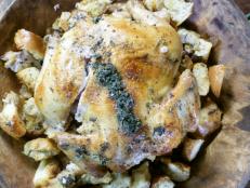 A close up of a roasted chicken with chestnut breading.